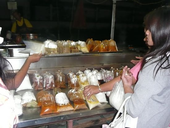 Essen in Tueten auf dem Nachtmarkt in Ayutthaya