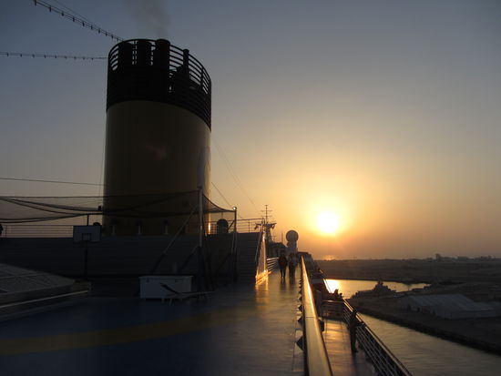 Sonnenuntergang an Deck mit Cocktail in der Hand