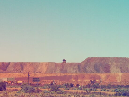 Die kleine Ameise auf der Bergkante ist in Wirklichkeit ein riesiger Lastwagen aus der Mine.