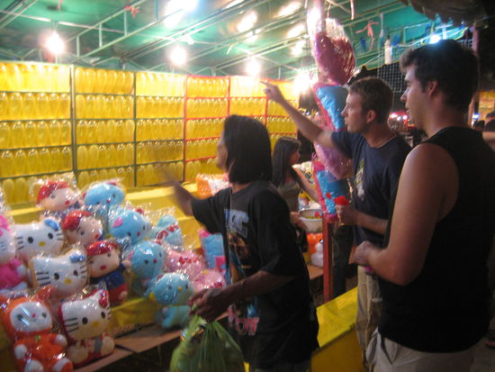 Die Jungs versuchen ihr Glueck beim Pfeil werfen.