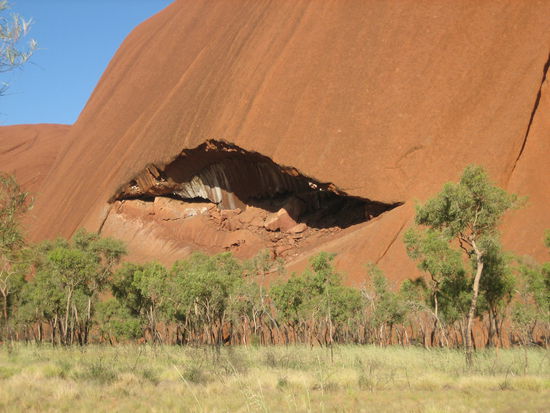 Walk um den Ayers Rock. In solchen Hoehlen lebten die Aborigines.