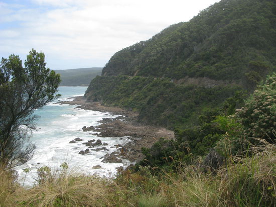 Kurz am Strassenrand angehalten; schon sieht man die steilen Klippen. Bei den gruenen Huegeln geht die Kuestenstrasse entlang.