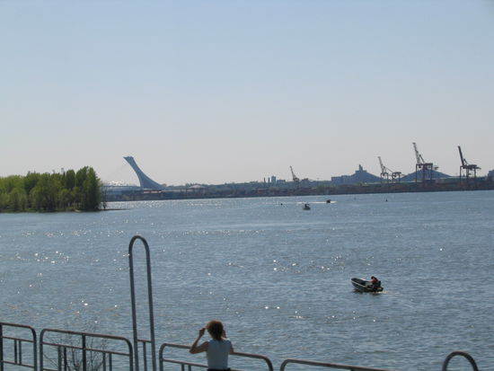Da kommen wir wieder zurueck nach Montreal. Blick ueber den St. Lorenzstrom. Links ist das Olypiastdion mit seine typischen Dackkonstruktion.
Rechts der neue Hafen.