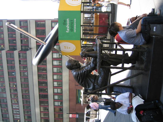 Da gehts schon etwas gemuetlicher in der 7th Avenue zu. Bekannt als Einkaufsstrasse von Designer-Klamotten, wie dieses Denkmal zeigt. Dahinter noch ein Knopf mit Nadel, Ueberdimensional natuerlich!