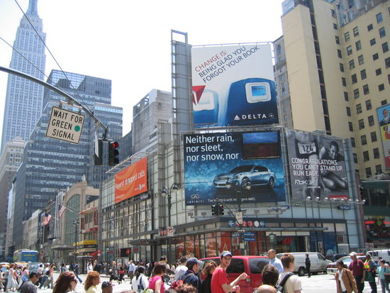 Strassenverkehr in der 7th Ave im Hintergrund das ueberall auftauchende Emprie State Building