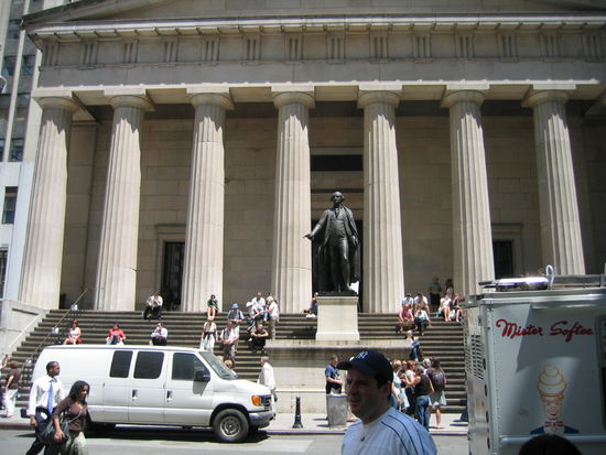 Hier in diesem Gebaeude, der Fedeal Hall, wurde Georg Washingtong als erster Praesident der Vereinigten Staaten vereidigt. Er wird hier auch dargestellt und schaut hinueber auf die Boerse der Wall Street.