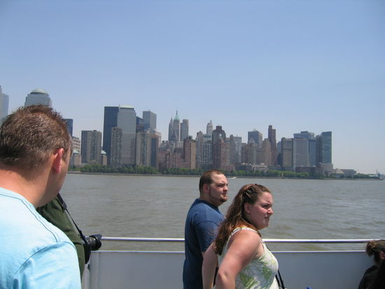 Von groesser Distanz die Skyline betrachtet und vordergruendig gewichtige Amerikanerinnen und Amerikaner.
