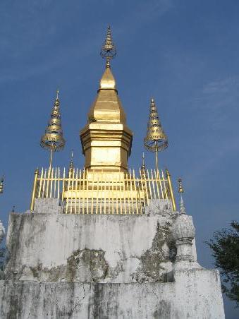 Der Phousi und That Comsi. Die höchste Erhebung auf der Landzunge ist gewiss schon vor vielen Jahrhunderten, lange bevor buddhistischer Verehrung, Stätte der Geisterverehrung gewesen.
Eine Legende berichtet: Ein Mönch hatte tief im Inneren des Berges einen Schatz gefunden. Die umliegenden Bewohner aber stahlen Diesen, und gruben den Mönch lebendig in der Grube ein. Über dem tiefen Loch errichteten sie dann den Reliquienschrein That Comsi. Als der König von dem Mord erfuhr, verurteilte er die Bevölkerung dazu, alle drei Stunden Trommeln und Zimbeln zu schlagen, um die erzürnten Berggeister von den Menschen fernzuhalten.