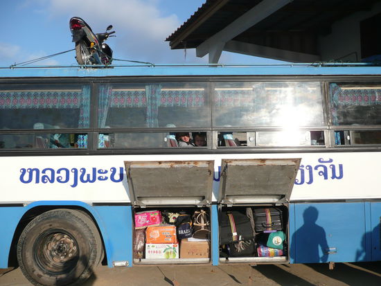 Abfahrbereit nach Phonsavanh. Die beiden Koffer mit den bunten Baendern im rechten Gepaeckraum sind unsre. Teilw. schon bisschen laediert, aber wir kommen wunderbar klar damit. Besser als ein Rucksack!!!