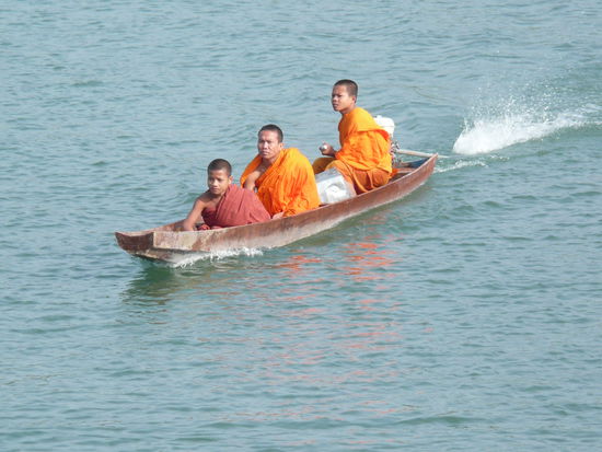 Drei Moenche kommen von ihrer morgentlichen Betteltour zurueck