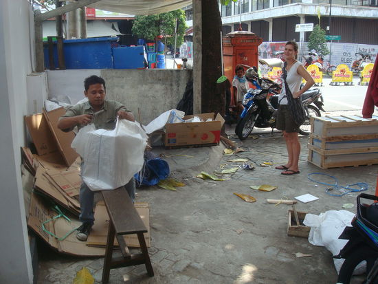 Nach dem Marktbesuch schicken wir ein Paket nach Hause. Zuerst wird die Schachtel zurechtgeschnitten und dann wird eine Art Blache drumgenaeht.