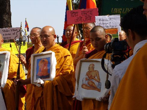 Moenche beim Gebet vor dem Tempel - der Gegenpol zu den lauten Protesten vor den Toren