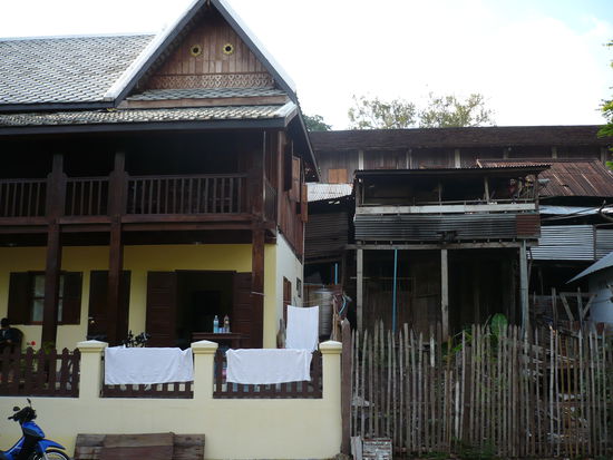 Kontrast in Luang Prabang: links schoenes hergerichtetes Haus, rechts "Pfahlhuette"