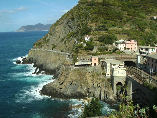 Blick von Riomaggiore auf den Bahnhof (Zug faehrt durch Tunnels) und links ist der Fussweg nach Manarola zu erkennen