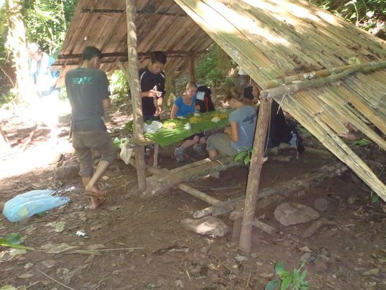 Der Tisch der Bambushuette wird mit Bananenblaettern gedeckt und das mitgebrachte Essen direkt darauf verteilt. Gegessen wird mit den Haenden. Uebrigens, das war sehr lecker!