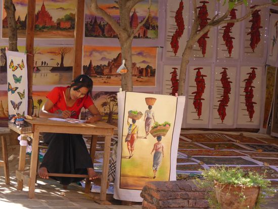 Sand painting: Rund um die Tempel von Bagan entwickelt sich diese "Kunst". Auf Baumwolle wird Sand aufgebracht und bemalt. Sie demonstrieren dir, wie abriebfest und waschbar und klein zusammen legbar das ganze ist. Hier eine Künstlerin bei der Arbeit.