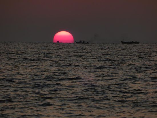 Sonnenuntergang mit aufziehender Aktivität der Fischerboote.
Zu Vollmond haben die Fischer keine Versuche unternommen, da beißen die Fische nicht oder gehen nicht in Netz. Jetzt (im Dunkeln) ziehen sie wie auf der Perlenkette aufgereiht, mit ihren Lichtern am Horizont entlang.