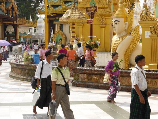 Swedagon Paragode Yangon
Gläubige mit Blumen als Geschenk und im Hintergrund Wunscherbitten an einem Alabaster Buddha.