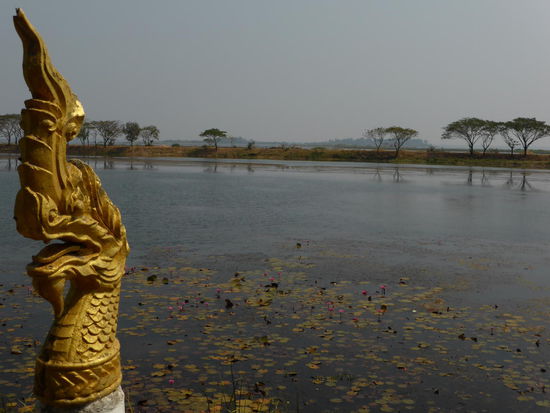 Park in Sakhon Nakhon mit Blick auf rote Seerosen und im Hintergrund der größte See in der Region.