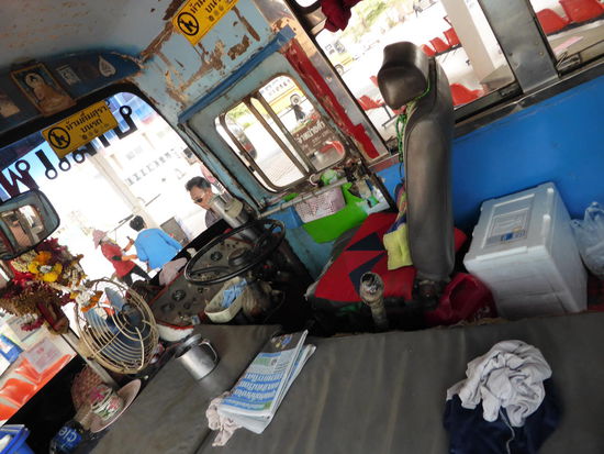 Um den Stiel des Lenkrades wider so ein schmuddeliges Tuch. Die Gangschaltung ist doch der Hammer! Ob die aus einander fallen würde, wenn jemand das tape entfernt? Die losen Kabel, das offene Blech und die Kreuz Schlitz Schraubenzieher verkehrt herum in dem Plastik Körbchen an der Tür!! Der Ventilator hängt am Stromkreis und bedient nur den Fahrer!
Der Rest wie immer, frische Blumengebinde an den Buddha Bildern, ein Wasserkuebel, ein frisches Tuch und - na ja, ganz schön alt.
Fährt aber in 2 Stunden nach Ban Paeng.