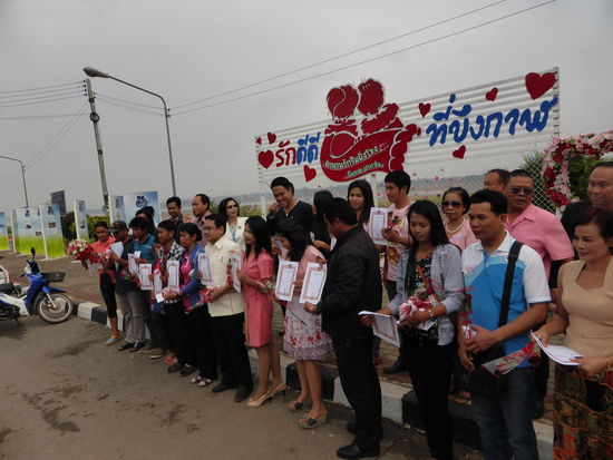 Gruppenfoto der Hochzeit am Valentinstag in Bueng Kan. In der ersten Reihe die Brautpaare mit der Urkunde. In der hinteren Reihe die Minister und Ehrengäste.