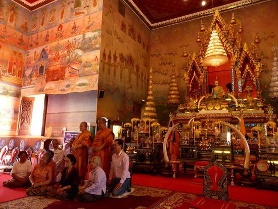 Wat Pho Chai mit dem berühmten Buddha in einem Winterumhang. Unten links eine Familie, die bei den Mönchen eine besondere Festlichkeit feiert. Der Tempel hat wunderschöne Wandbemalung mit den Geschichten von Buddha.