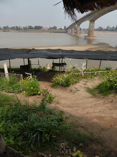 Unterhalb der "friendship bridge" genießen wir einen eisgekühlten Cappuccino. Die Anlage ist top gepflegt und wird von mehreren kleinen Restaurants bedient. Matten, Kissen, kleine Tische auf dem Boden oder in Hütten.
Na und mit Blick auf Laos!
... Und das ganze hält so lange, bis es vom Wasser weg gespült wird.