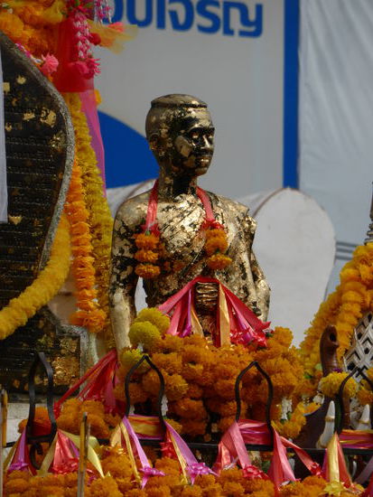 Die hochverehrte Nationalheldin wird mit Gold Plättchen und Blumen verziert, permanent beten dort Menschen.