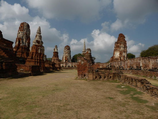 Wat Mahathat in Sonnenaufgang-Stimmung. Viele dieser alten Ruinen, von der UNESCO anerkannt in Parkanlagen. Die Absenkungen führen bald zu nicht mehr reparablen Schäden. Die ganze Stadt ist durchsetzt mit Chedis Stupas und anderen Ruinen.