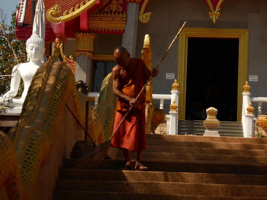 Der Aufgang zum Wat wird von einem Mönch gefegt.