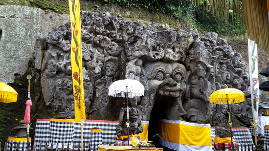 Eingang in die Elefant Cave! GOA GAJAH  es soll sich bei der Fratze am Eingang um die älteste auf Bali vorhandene  Darstellung vom BOMA handeln, dem Sohn des Wassergottes VISHNU und der Mutter der Erde IBU PERTIWI. Stammt aus dem 11. Jahrhundert.