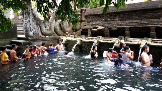 Das Quellheiligtum PURA TIRTA EMPUL wird seit über 1000 Jahren von den Balinesen als heiliges Wasser zum Baden genutzt.  Die Gläubigen stehen Schlange und gehen komplett mit Klamotten von einer der 12  Quellen zur nächsten.  Sie haben Opfergaben und Gefäße, um Wasser mit zu  nehmen.