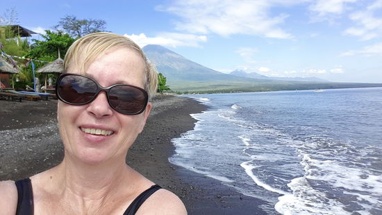 Und ein Mir-geht's-gut-Foto 
Im Hintergrund der große Berg ist der GUNUNG AGUNG, und rechts daneben der Vulkan, wo wir mit dem Tagesausflug bei schlechtem Wetter oben waren.