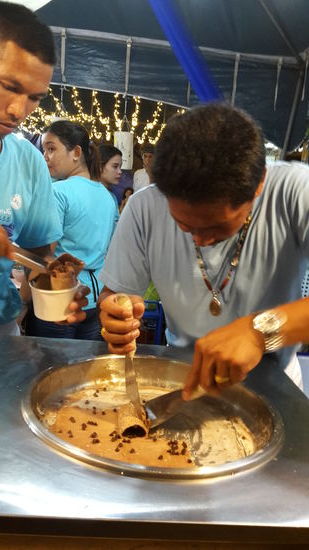 Die Eismasse ist zerhackt und vermischt und die Rollen kommen in den Becher.