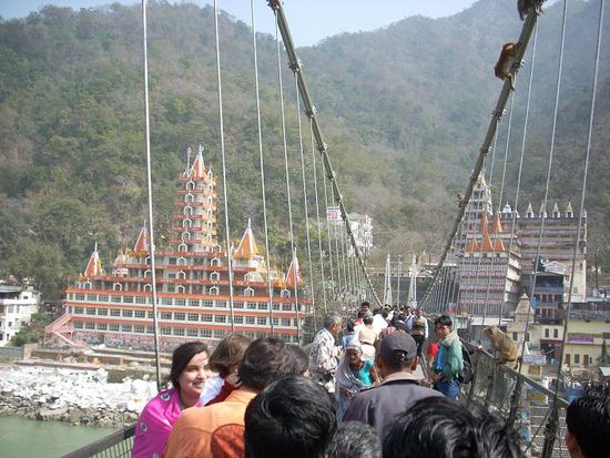 Die Bruecke in Laxman Jhula ueber den Ganges. Im Hintergrund ein 12 Etagen-Tempel aus dem Jahr 1971. Ganz links im Bild unser Guesthouse.