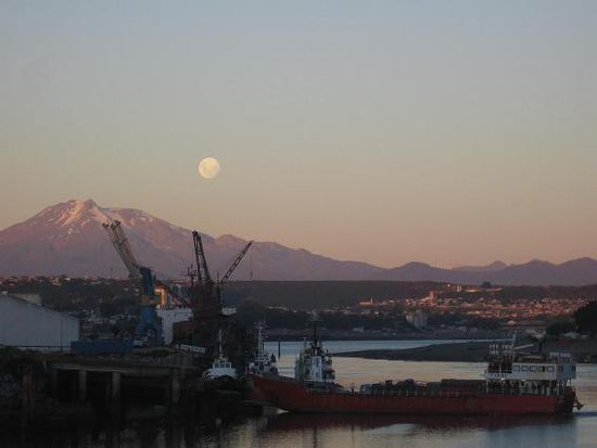 Hafen von Puerto Montt mit Mondaufgang ueber dem Vulkan Calbuco