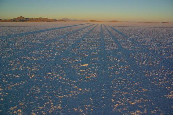 Sonnenaufgang ueber dem Salar de Uyuni, man wirft ganz schoen lange Schatten.