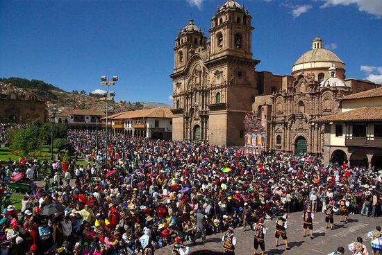 Menschenmassen fuellen die Strassen. Vorne weg gehen Taenzer ...