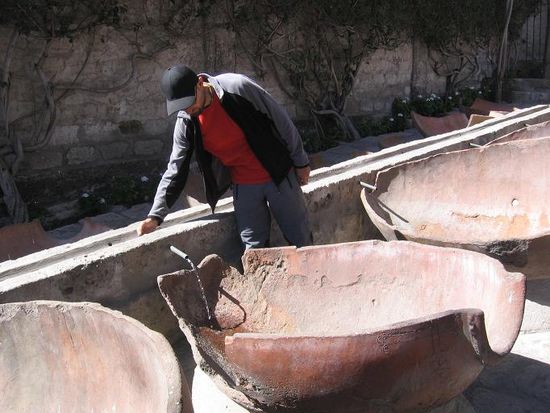 In diesen Tonkruegen wurde die Waesche gewaschen. Wenn man so wie Markus hier den Abfluss versperrt, fliesst das Wasser in den Krug