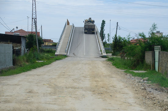 Abenteuerliche Brücke, steil, und davor und dahinter Schotter