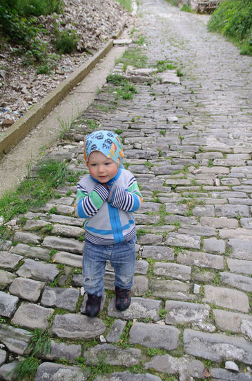 Georg zeigt auf sich, dann auf die Strasse, und sagt "Geog". Er ist offensichtlich stolz daß er auch auf diesen holprigen Steinwegen selbst gehen kann.