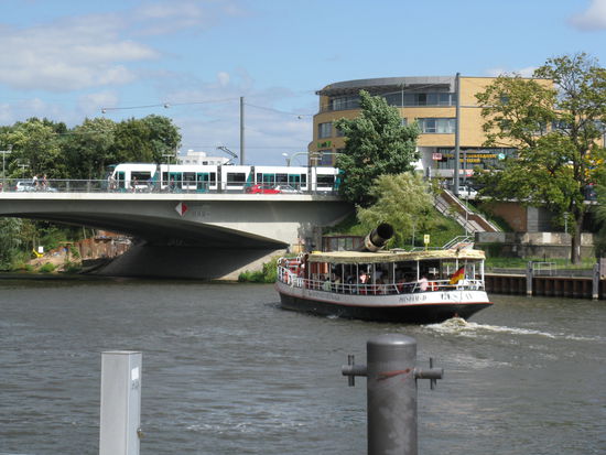 Weiße Flotte mit Dampfschiff im Vordergrund dahinter Tram auf Langer Brücke vor dem Hauptbahnhof Potsdam