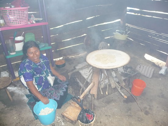 Indiofrau bereitet bei beißenden Rauch frische Tortillas  zu