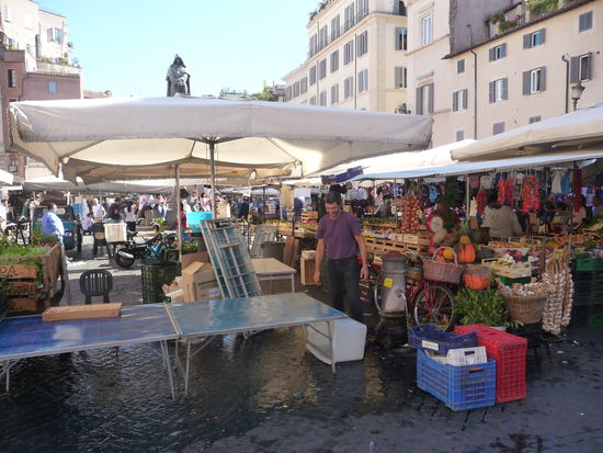 Campo de Fiori schönster und bekanntester Markt Roms wo Obst,Gemüse,Fisch und Gewürze verkauft werden.Am Nachmittag nachdem der Markt verschwunden ist öffnen viele Cafes und Bars in denen bis in die Nacht hinein gefeiert wird.
