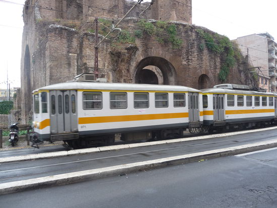 Überlandstraßenbahn vor römischen Bauwerk