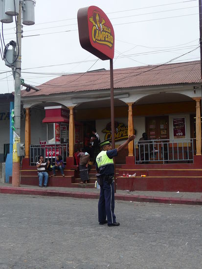 Polizist regelt den Verkehr vor Hänchenrestaurant Pollo Campero in Solola - Pollo Campero ist eine große und bekannte Fast Food Kette aus Guatemala.
