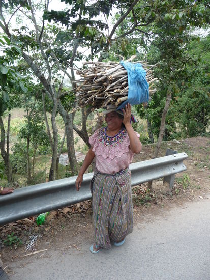 Fröhliche Mayafrau beim Transport von Waren