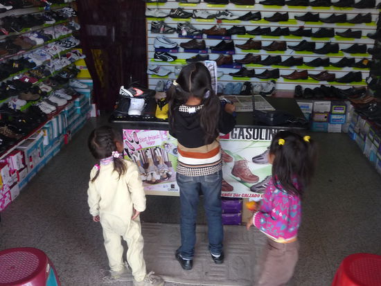 Kinder bewundern das Angebot an Schuhen