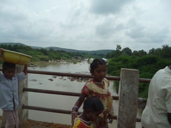 Malaprabha Fluß direkt neben den Tempeln von Pattadakal mit vielen Menschen die diesen gerade überqueren