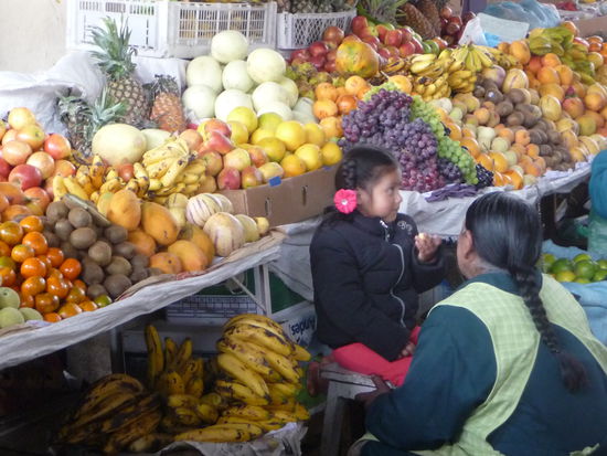 Enkelin und Großmutter mit Ihren Obststand in der Markthalle von Cusco
